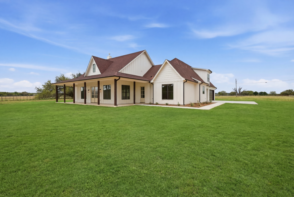 Custom Texas home with wraparound porch on open land in Hood County