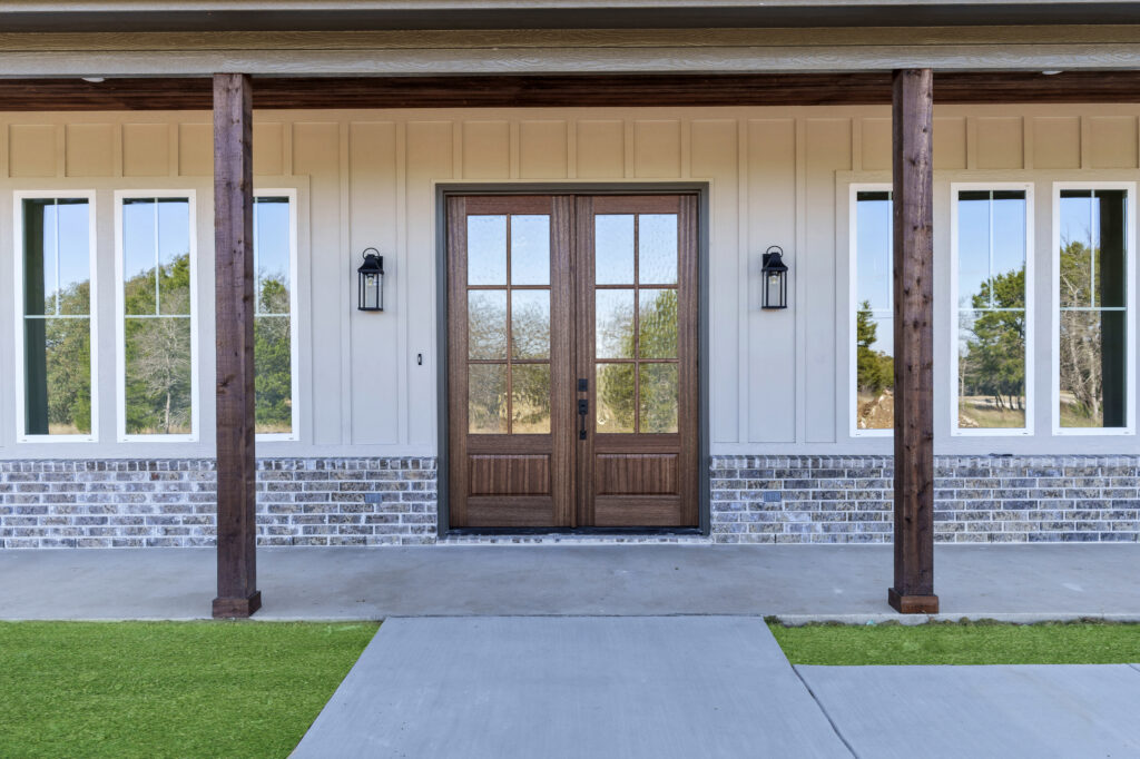 Custom wood front entry doors with covered porch by True Texas Builders