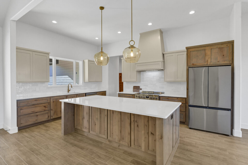 Custom kitchen with large island, wood cabinetry, and modern lighting
